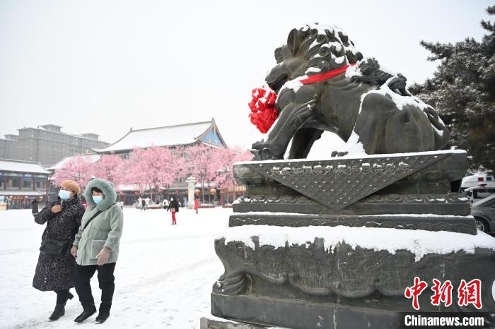 2月13日，民眾在呼和浩特市大召廣場雪中漫步?！⑽娜A 攝