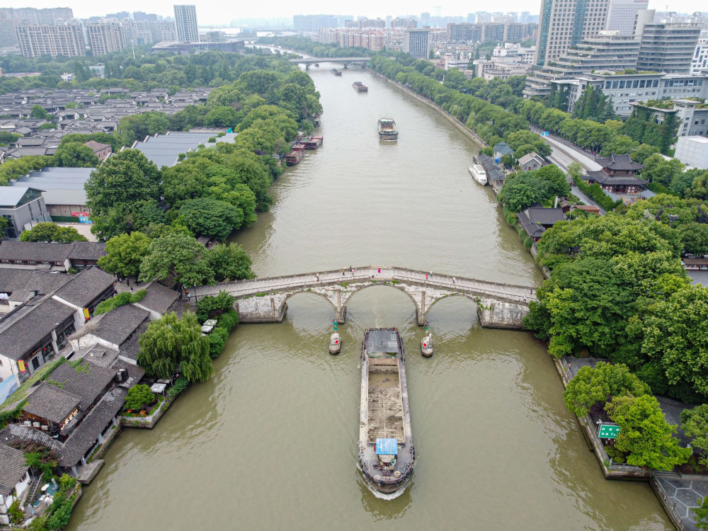 5月27日，一艘貨船駛過京杭大運河南端標志建筑杭州拱宸橋。(無人機照片)新華社記者江漢 攝