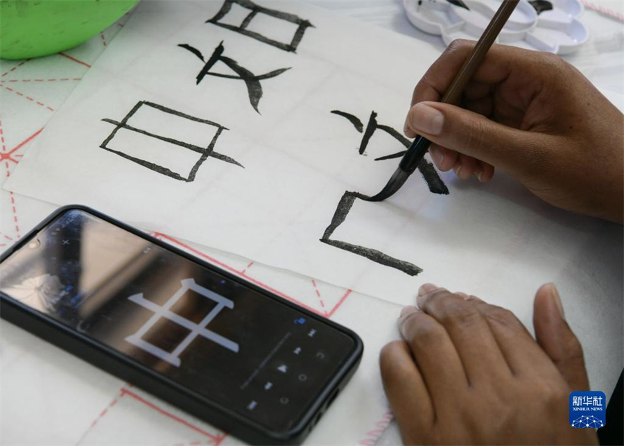 4月18日，肯尼亞學(xué)生在內(nèi)羅畢大學(xué)孔子學(xué)院舉辦的活動(dòng)上寫(xiě)毛筆字。肯尼亞內(nèi)羅畢大學(xué)孔子學(xué)院18日舉辦“中文，增進(jìn)文明對(duì)話”主題活動(dòng)，慶祝即將到來(lái)的第14個(gè)聯(lián)合國(guó)中文日?？夏醽唽W(xué)生參與互動(dòng)，進(jìn)行書(shū)法、剪紙、唱中文歌等活動(dòng)。新華社記者 韓旭 攝