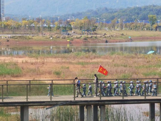 　　10月24日，秋游的幼兒園小朋友在老師帶領(lǐng)下走在清水塘公園里的木橋上。本報(bào)記者 常雯宜攝