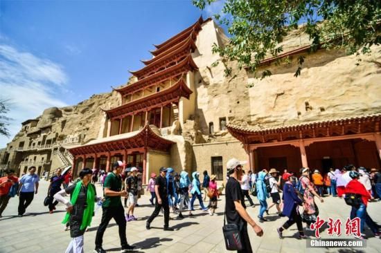 資料圖：莫高窟標(biāo)志性建筑“九層樓”前的游人如織。王斌銀 攝