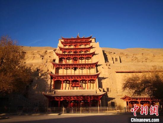 圖為11月7日，沐浴在晨光中的敦煌莫高窟標(biāo)志性建筑“九層樓”?！●T志軍 攝