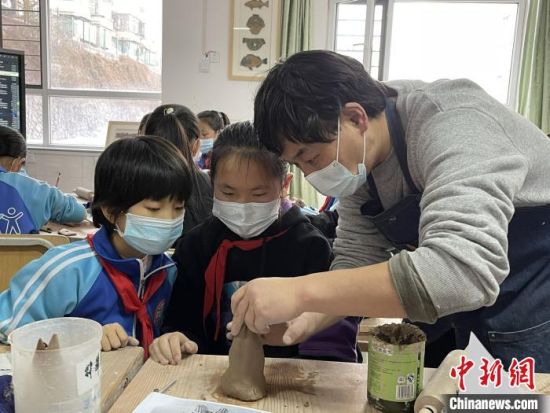 圖為西寧市勞動(dòng)路小學(xué)教師賈煜與學(xué)生一起制作陶藝?！≈苋鸪阶?攝