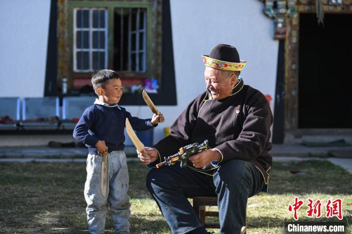 圖為米林縣扎西繞登鄉(xiāng)彩門村64歲的洛桑帶著孫子巴桑在院子的草地上玩耍?！『闻罾?攝