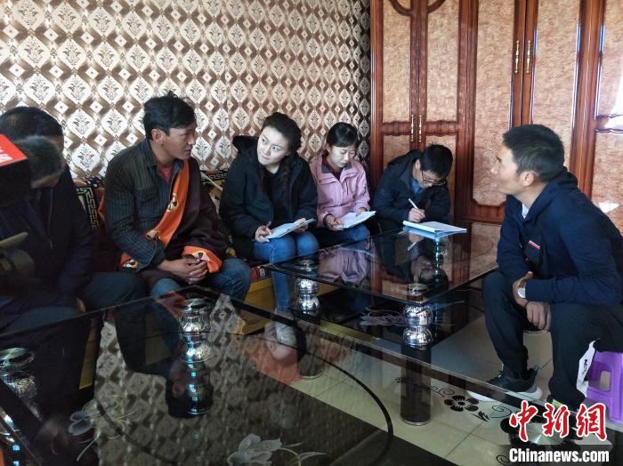 圖為調(diào)查組工作人員正在入戶調(diào)查?！∑钤鲚?攝
