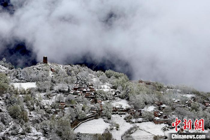 雪后的藏寨和碉樓構(gòu)成美麗的雪景?！〗党鯘衫?攝