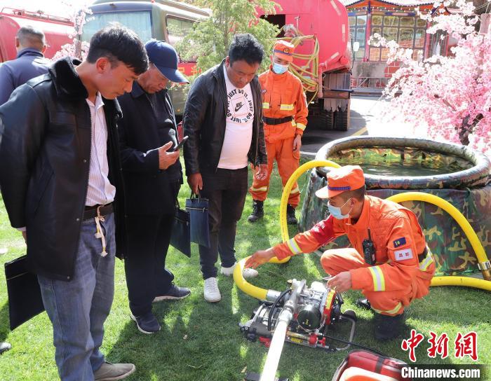 圖為森林消防員為護林員講解滅火裝備的使用方法。　昌都市森林消防支隊 供圖