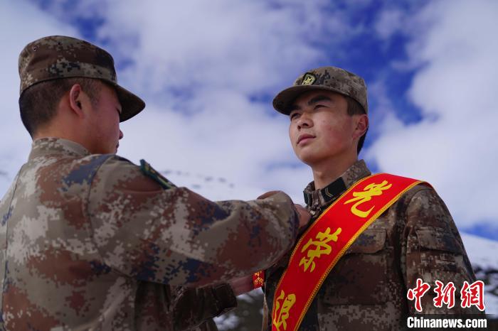 排長王朝偉(圖左)給退伍老兵佩戴大紅花?！∥鞑厣侥宪姺謪^(qū)某團供圖