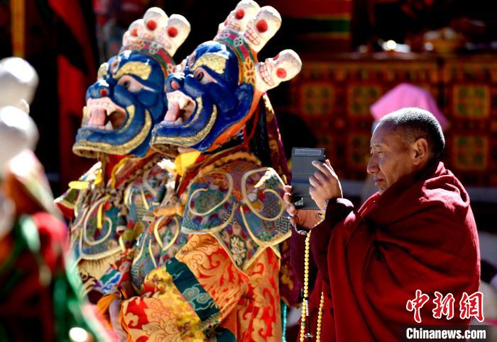 2月19日，正在拍攝跳神活動(dòng)的僧人?！±盍?攝