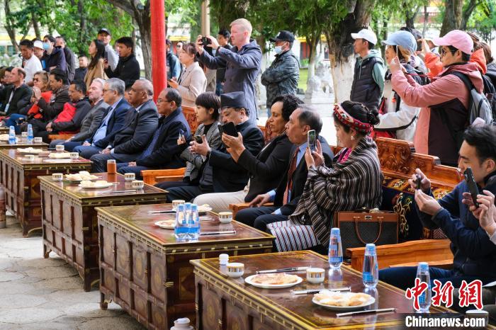 5月19日，中外嘉賓在羅布林卡和游客一起觀看藏戲。　江飛波 攝
